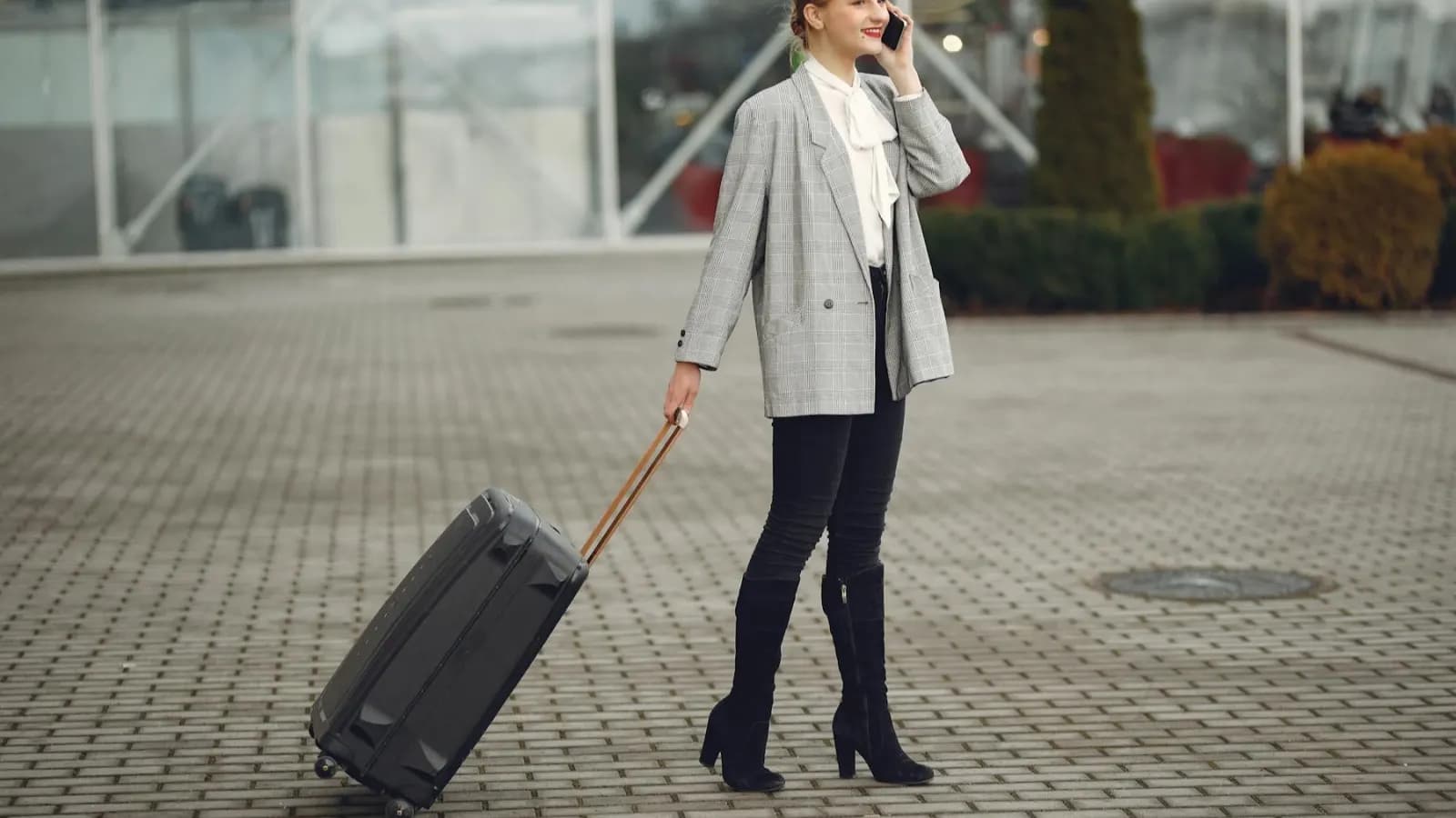 Traveler with a suitcase arranging an airport transfer by phone